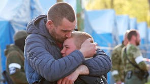 Azovstal steel plant employee Maxim, last name withheld, evacuated from Mariupol, hugs his son Matvey, who had earlier left the city with his relatives, as they meet at a temporary accommodation centre during Ukraine-Russia conflict in the village of Bezimenne in the Donetsk Region, Ukraine