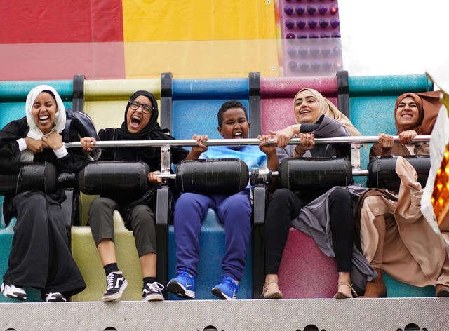 People enjoy theme park rides at a funfair at Small Heath Park in Birmingham, as the holy month of Ramadan comes to an end and Muslims celebrate Eid al-Fitr