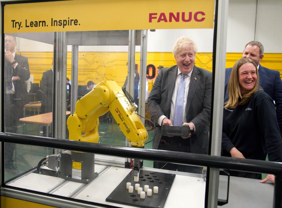 Prime Minister Boris Johnson operates a robotic arm to grab plastic objects, during a campaign visit to Burnley College Sixth Form Centre (Peter Byrne/AP)