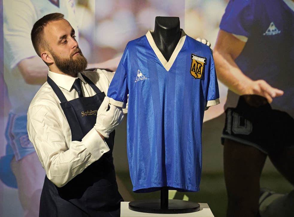 A Sotheby’s gallery assistant with Diego Maradona’s 1986 World Cup Hand of God shirt (Jonathan Brady/PA)