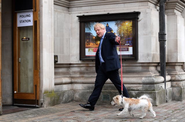 英国首相鲍里斯·约翰逊带着他的爱犬 Dilyn 抵达投票站，在威斯敏斯特的地方选举中投票, 伦敦