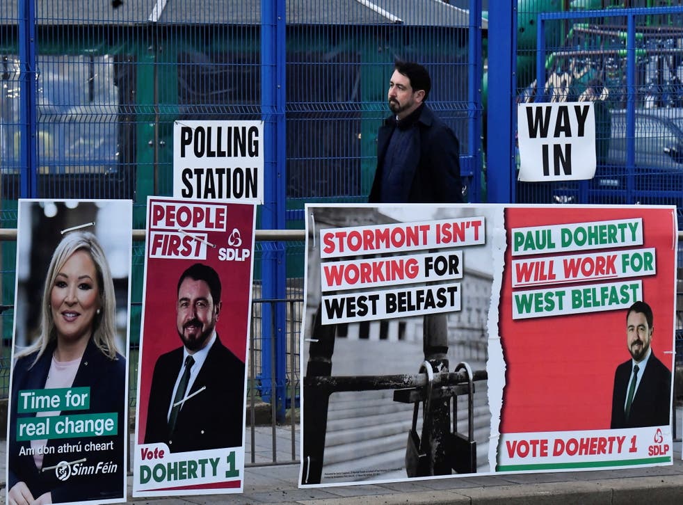 <p>SDLP candidate Paul Doherty walks past election posters outside a polling station during the Northern Ireland Assembly elections, on Glen Road, in West Belfast, Irlande du Nord 5 May 2022</ppgt;