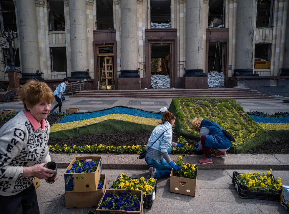 <p>Valentina Orlova and other volunteers plant pansies</p>