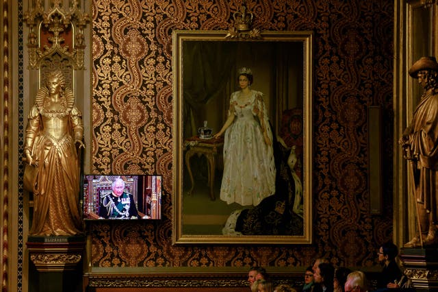Britain's Prince Charles, Prince of Wales appears on a screen next to a painting of Queen Elizabeth at the Royal Gallery as he delivers the Queen's Speech during the State Opening of Parliament at the Houses of Parliament, ロンドンで