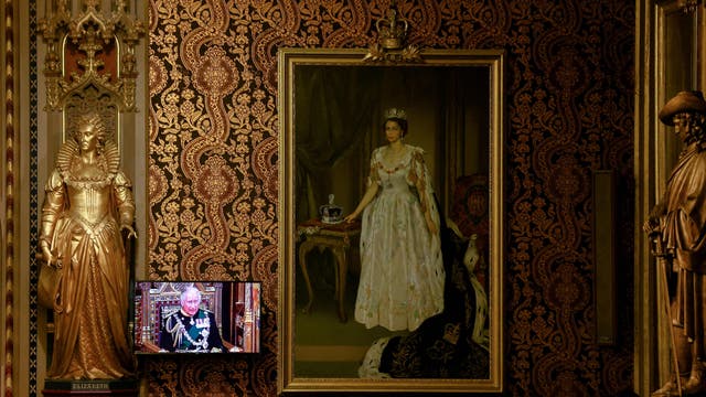 Britain's Prince Charles, Prince of Wales appears on a screen next to a painting of Queen Elizabeth at the Royal Gallery as he delivers the Queen's Speech during the State Opening of Parliament at the Houses of Parliament, 在伦敦