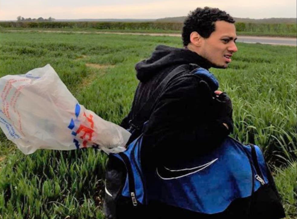 <p>Callum Wheeler in fields near Aylesham, Kent, carrying a blue holdall with what prosecutors claim is the murder weapon poking out </p>