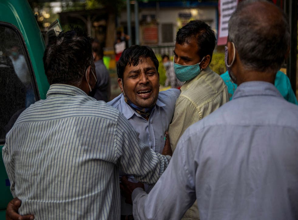 <p>A man grieves as his family member is declared dead outside the coronavirus casualty ward at the Guru Teg Bahadur hospital in New Delhi on 23 April 2021</磷>