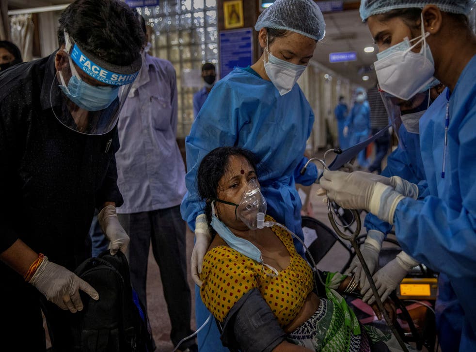 <p>A patient suffering from Covid-19 is attended to by hospital staff inside the emergency ward of the Holy Family hospital in New Delhi on 29 April 2021</磷>