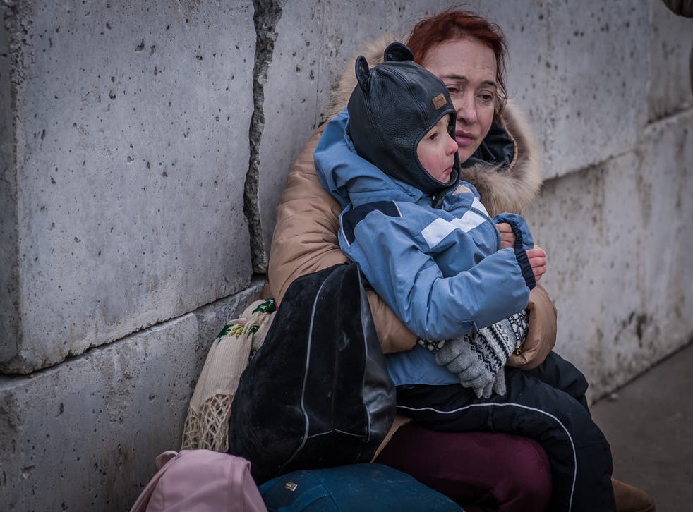 <p>A woman with a child waits to be evacuated in Kyiv</p>