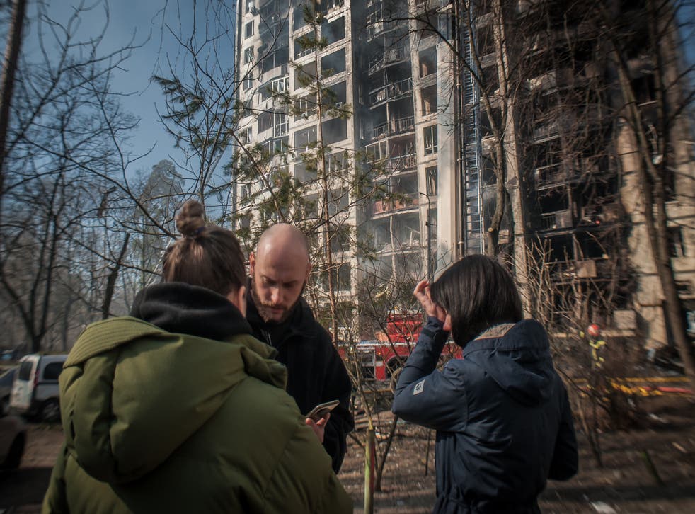 <p>Residents of a building in Kyiv watch the fire extinguishing after an morning air attack</磷>