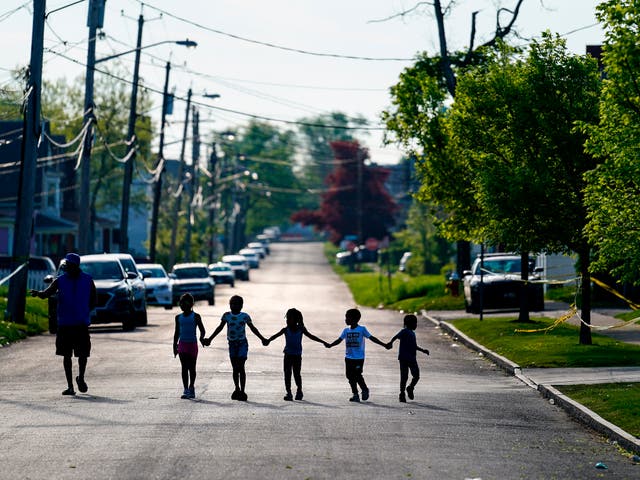 Children walk hand in hand out near the scene of a shooting at a supermarket in Buffalo, NY