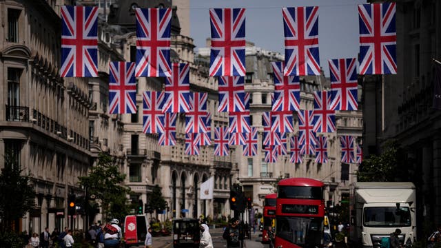 People cross Regent Street, decorated with flags to mark the upcoming platinum jubilee , to mark the 70-year reign of Queen Elizabeth II