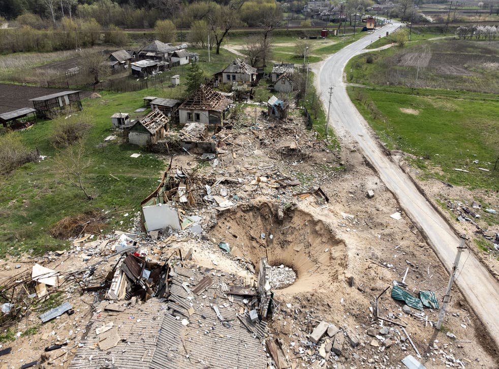 <p>An aerial view shows a crater and destroyed homes in the village of Yatskivka, eastern Ukraine</s>