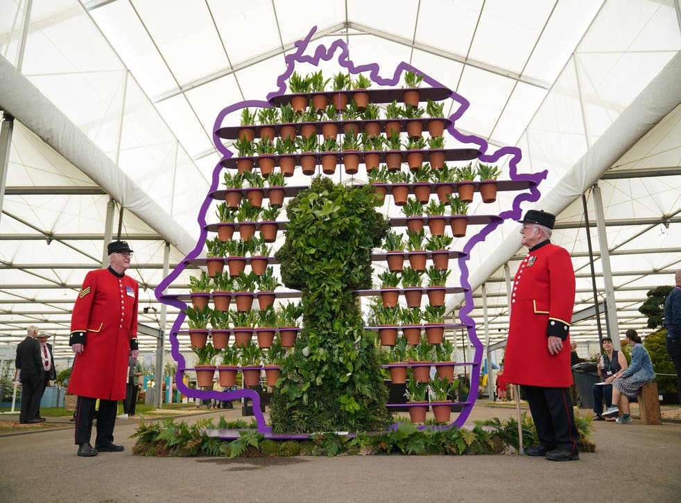Chelsea Pensioners Ted Fell, la gauche, and George Reid pose beside florist Simon Lycett’s The Queen’s Platinum Jubilee (Yui Mok/PA)