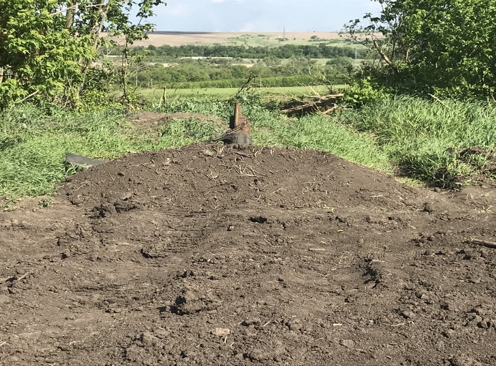 <p>A makeshift burial site for the bodies of Russian forces around the village of Vilkhivka near Kharkiv</p>