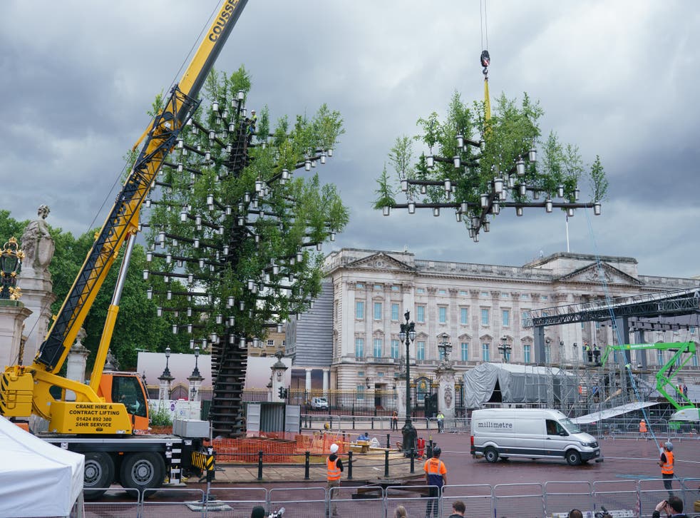 Construction workers use a crane to lift the top section of the Queen’s Green Canopy (QGC) Tree of Trees (Dominic Lipinski/PA)