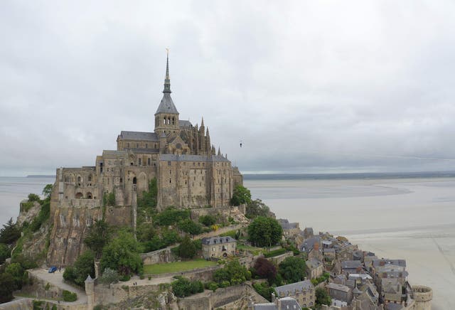 This aerial view shows French tightrope walker Nathan Paulin walking on a slackline close to Le Mont Saint-Michel abbey, north-western France