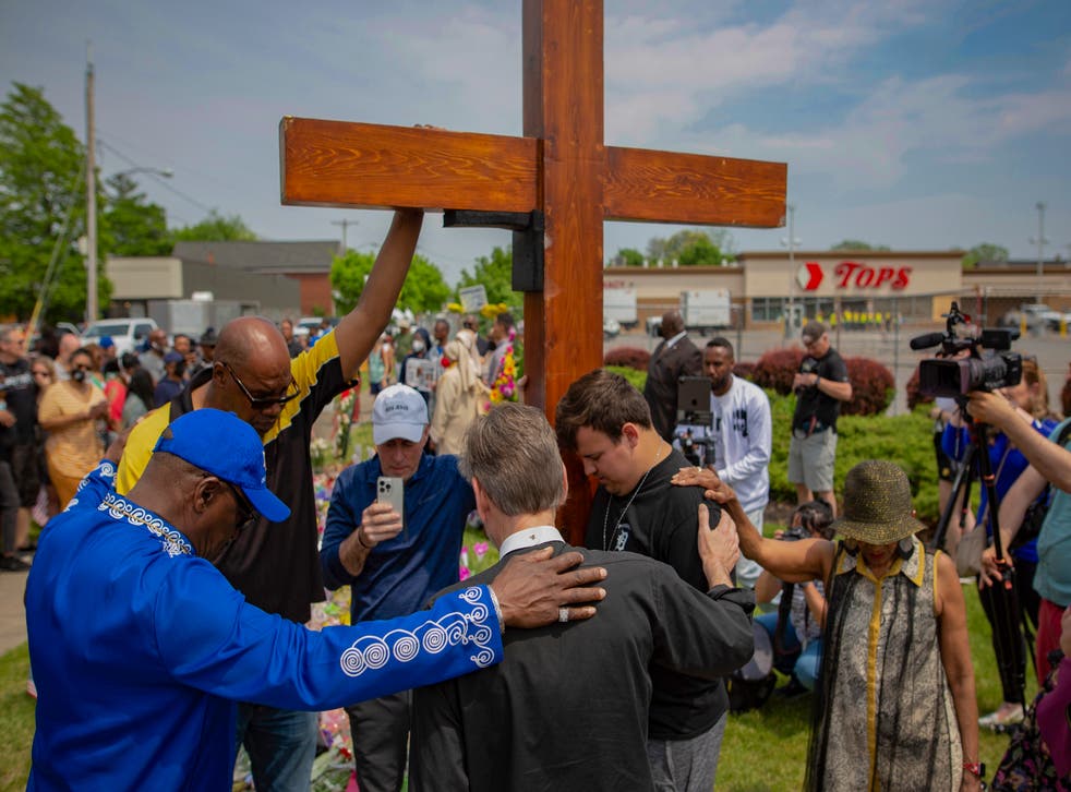 <p>Community members pray at a memorial site for the victims of the Buffalo mass shooting  </磷>