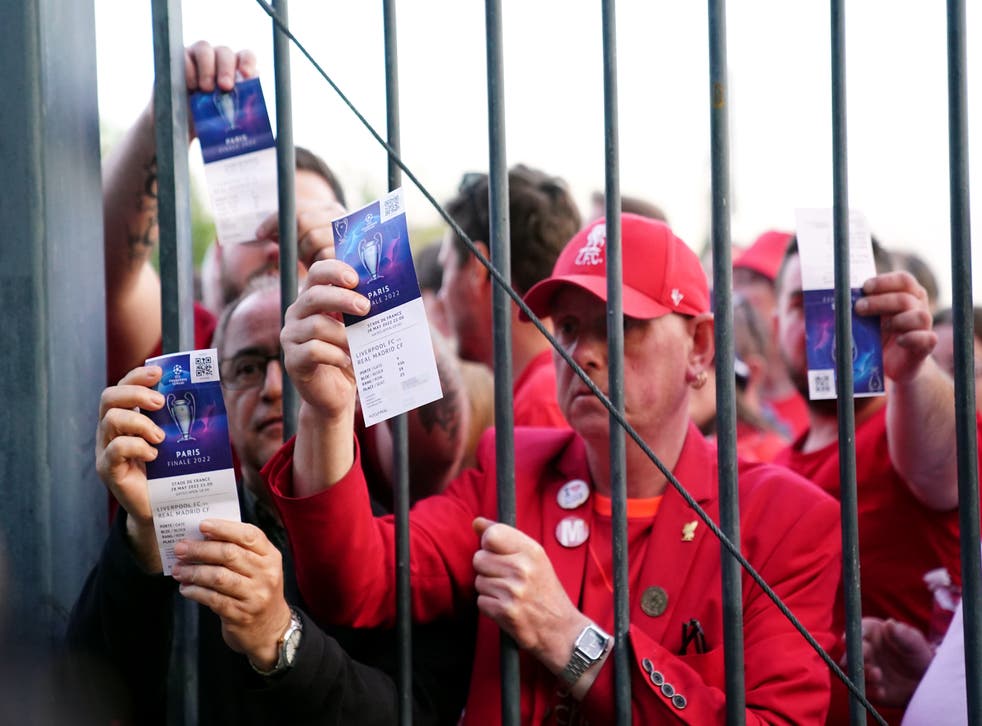 Liverpool fans stuck outside the ground show their match tickets (Adam Davy / PA)