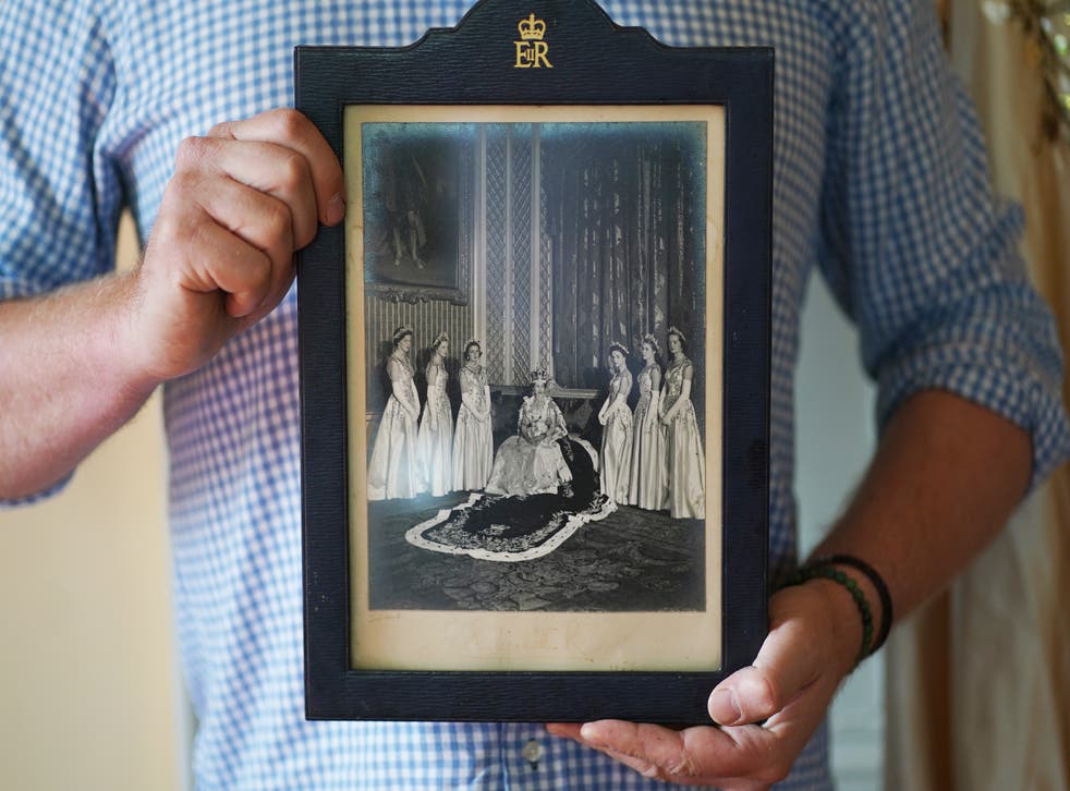 ****HOLD HOLD HOLD. FOR RELEASE 11AM SUNDAY 29TH MAY WITH AN EMBARGO UNTIL 00.01AM MONDAY 30TH MAY****Rory Campbell, at his home in Randalstown, Co. Antrim, holding a photograph of his late mother Lady Moyra Campbell (left) with Queen Elizabeth II on Coronation day. The dress Lady Campbell wore will go on display as part of a special diamond jubilee exhibition at Enniskillen Castle. Picture date: Thursday May 26, 2022. PA Photo. See PA story ROYAL Jubilee Ulster. Photo credit should read: Brian Lawless/PA Wire