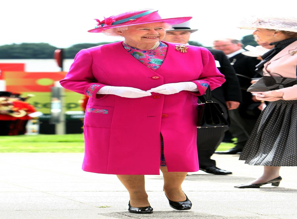 The Queen in a bold coloured coat, matching hat, black shoes and white gloves and carrying her famous handbag (David Davies/PA)