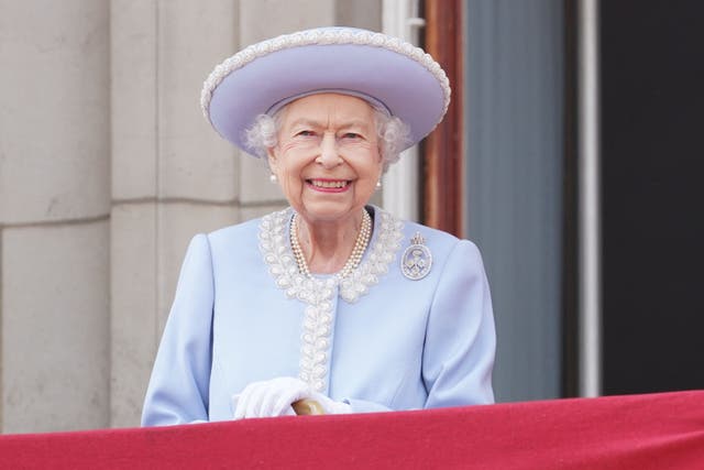 La reine Elizabeth II de Grande-Bretagne se tient sur le balcon du palais de Buckingham et les troupes défilent lors du défilé de l'anniversaire de la reine, la parade de la couleur