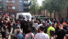 Crowd stops officers taking away man accused of immigration offences by blocking van
