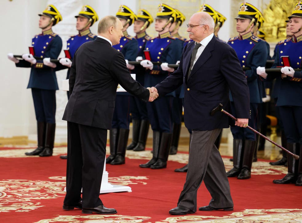 <p>Vladimir Putin shakes hands with film director Nikita Mikhalkov at a state award ceremony</p>