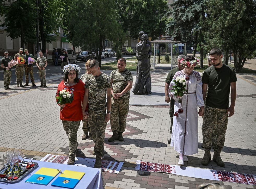 <p>Two pairs of Ukrainian soldiers get married in Druzhivka, eastern Ukraine on 12 June, 2022</p>