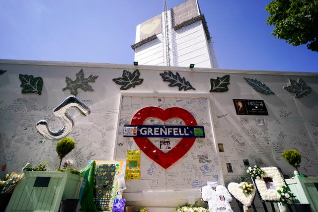 Fleurs et hommages laissés à l'extérieur de la tour Grenfell à l'occasion du cinquième anniversaire de l'incendie qui a tué 72 gens