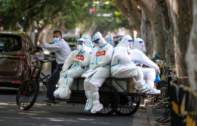 Medical workers ride on a cargo bicycle, in Shanghai, China
