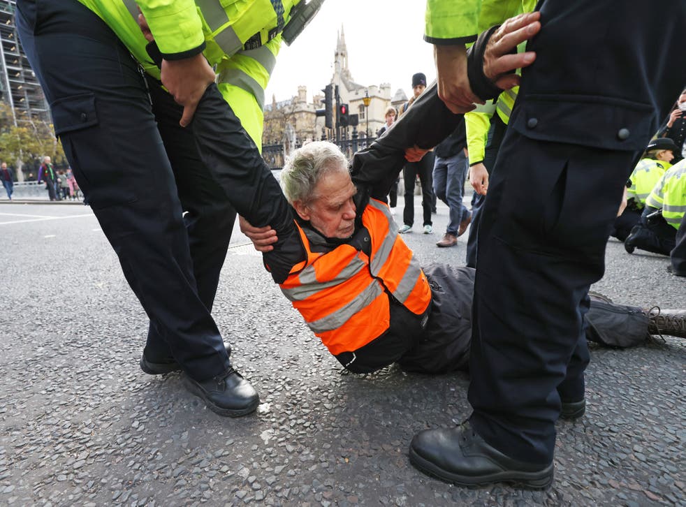 Police remove an Insulate Britain protester blocking the road in Parliament Square (James Manning/PA)