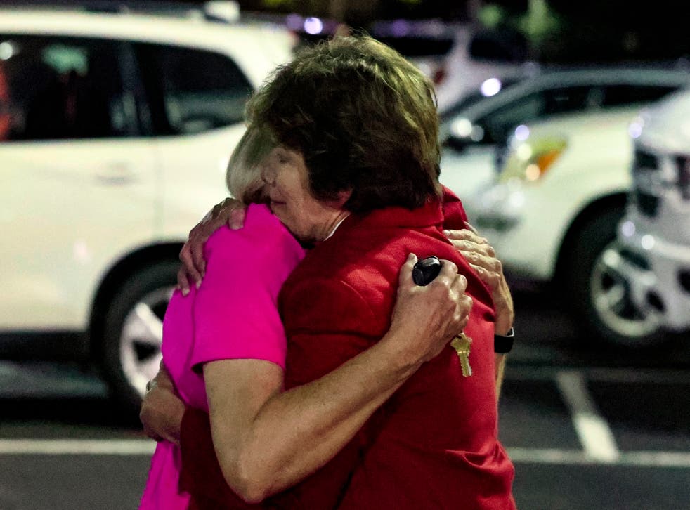 <p>Members of the Saint Stephens Episcopal Church, in Vestavia, 阿拉巴马州, embrace after a gunman opened fire at a pot luck din磷er</p>