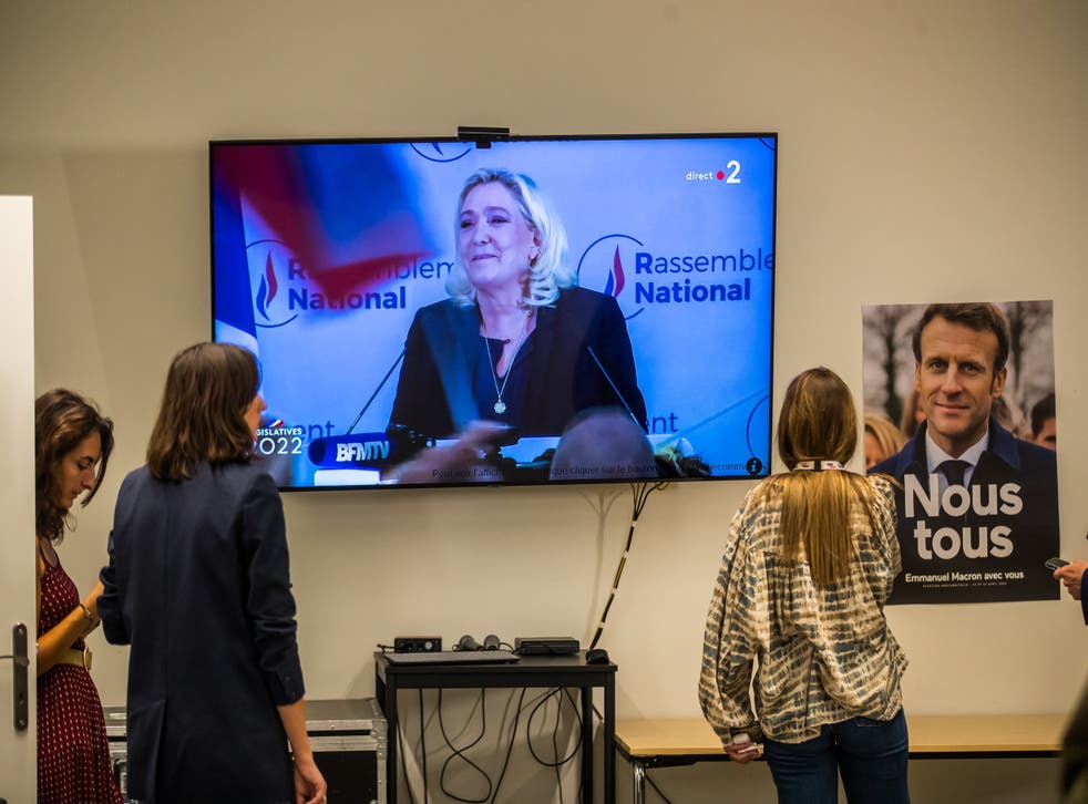 <p>Journalists and supporters look at Marine Le Pen delivering a speech on TV after the results of the second round of the French legislatives elections</p>