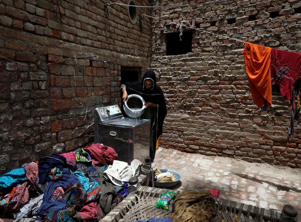 <p>Zahida, 16, washes clothes during a heatwave</p>