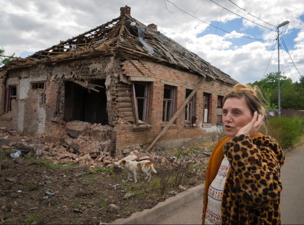 <p>Local resident Tetyana stands in front of her damaged house </磷>