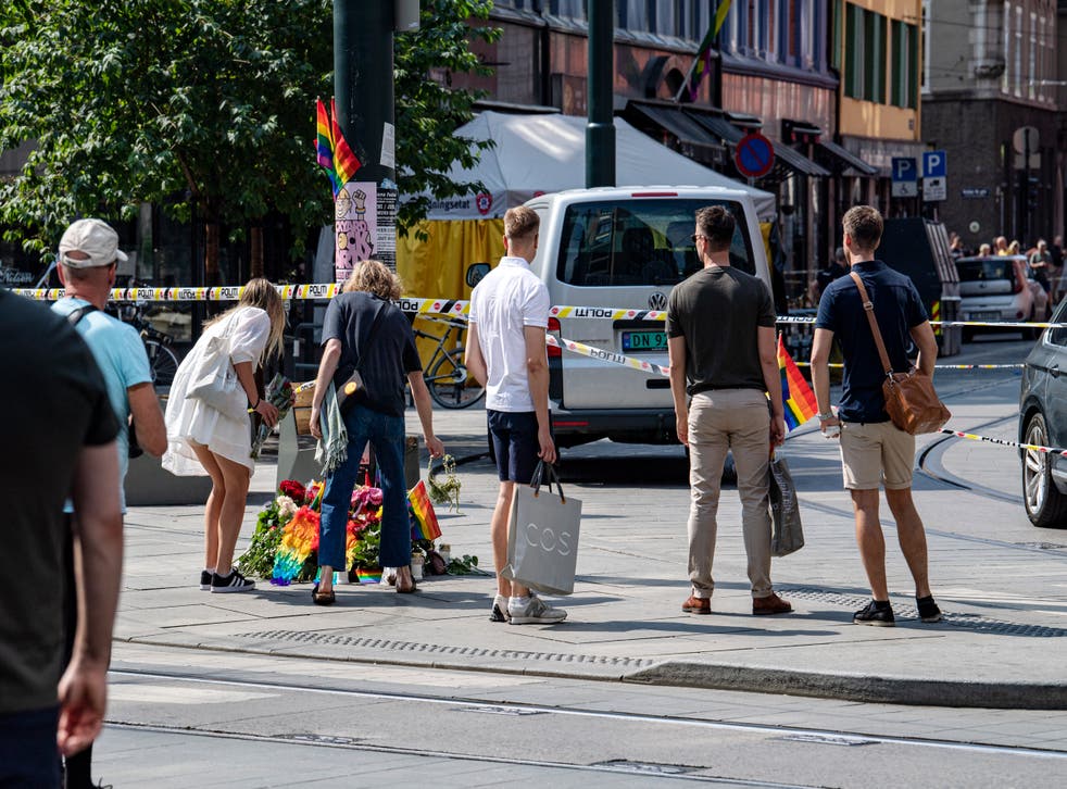 <p>People lay rainbow flags along the street near a restaurant with windows shattered by the shooting</bl>