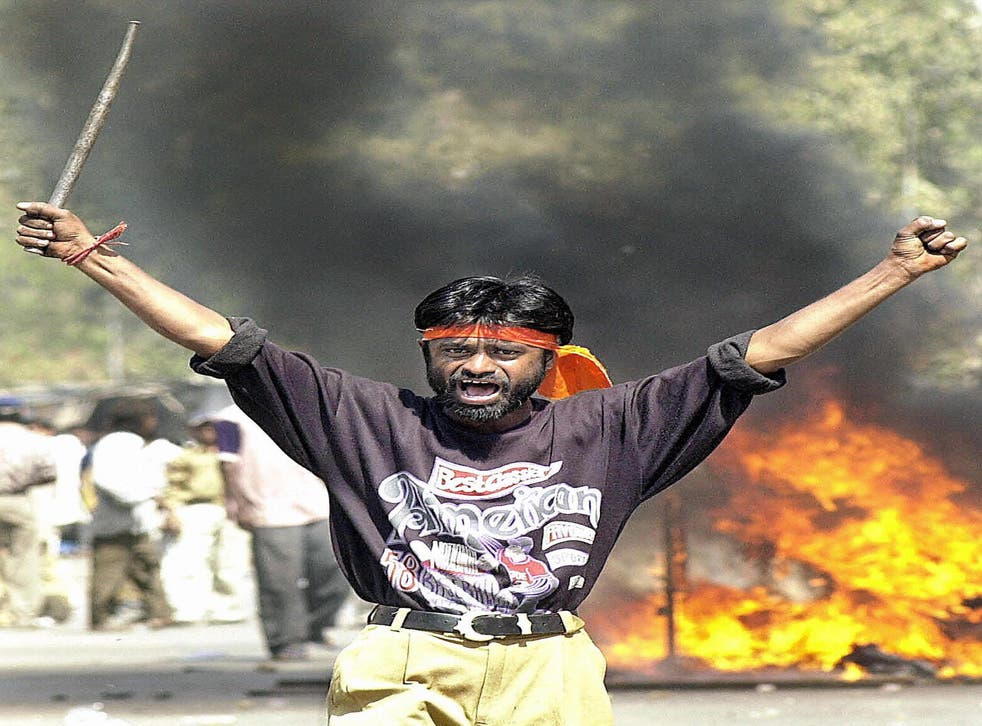 <p>This picture taken 28 fevereiro 2002 shows a Bajranj Dal activist armed with a iron stick shouting slogans as a mob burned Muslim shops and attacked residences at Sahapur in Ahmedabad<pp>