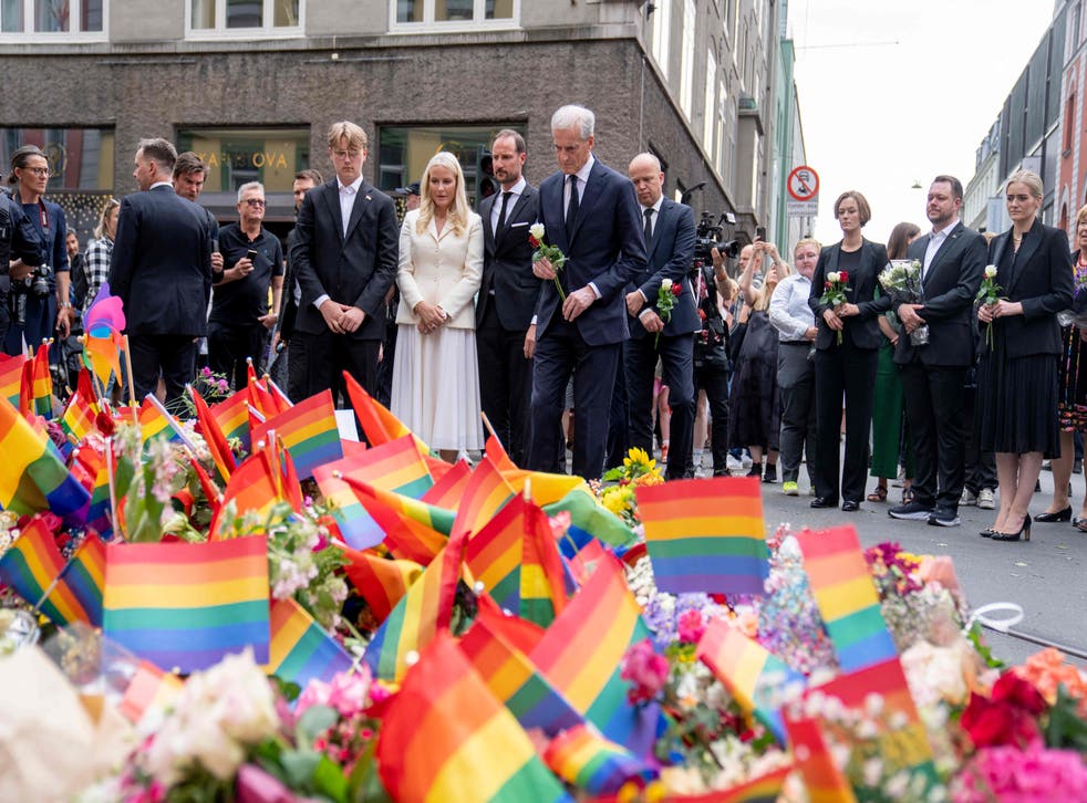 <p>Gahr Store (right), Mette-Marit and Crown Prince Haakon (centre) lay flowers at the crime scene on Saturday</p>