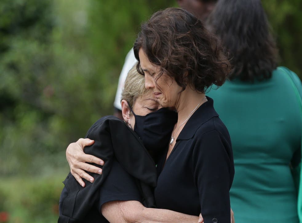 <p>Alessandra Sampaio (R) embraces her mother Maria Lucia Farias Sampaio at her husband’s funeral service</p>