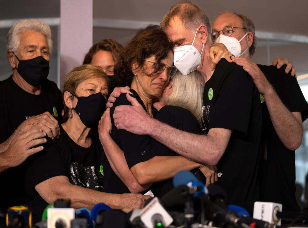 <p>Relatives mourn as Alessandra Sampaio, centre, embraces her sister-in-law Sian Phillips</p>