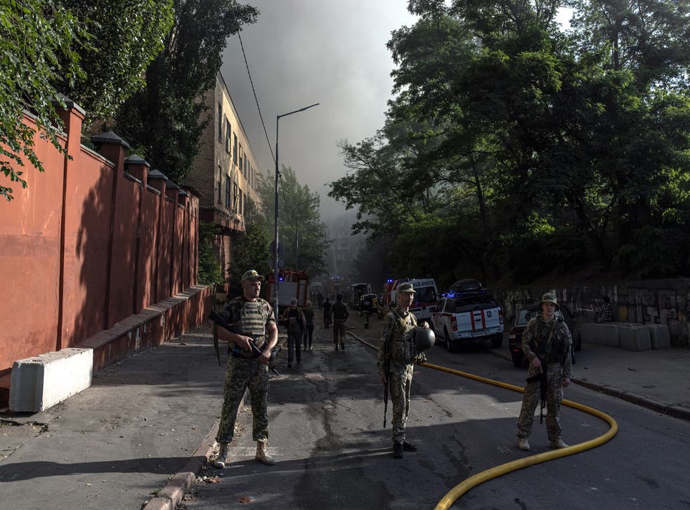 <p>Ukrainian soldiers stand guard in Kyiv’s Shevchenkivsky district after strikes hit the capital</磷>
