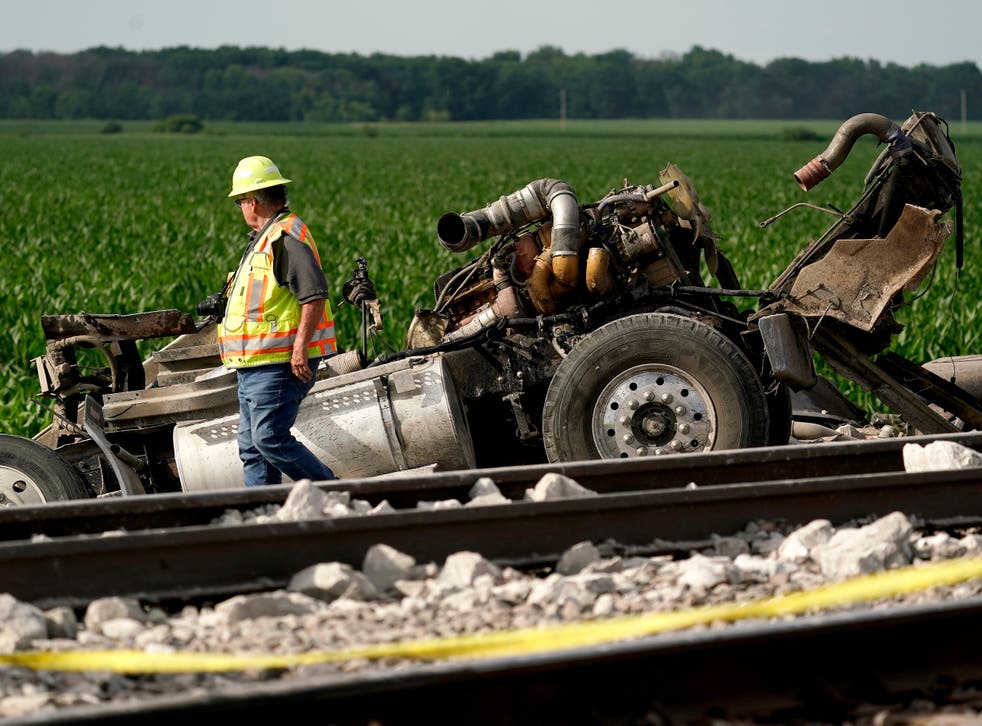<p>A worker inspects the remains of a dump truck hit by an Amtrak train near Mendon, Missouri on Monday 27 June 2022</磷>