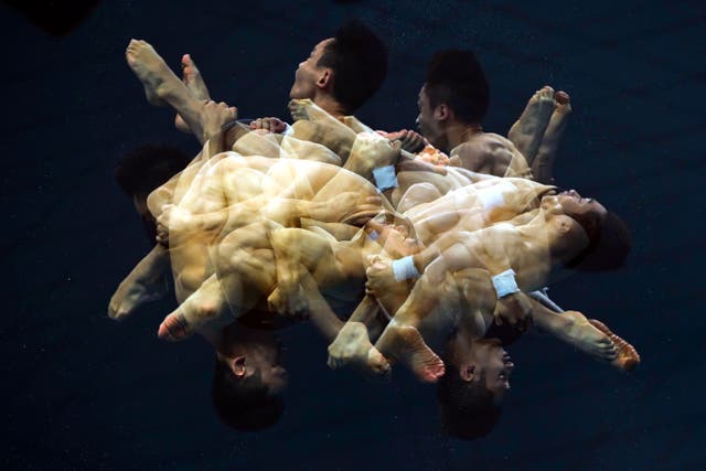 A multiple exposure picture of Hao Yang and Junjie Lian competing in the men’s Synchronized 10m Platform Diving preliminaries of the FINA World Aquatics Championships at Duna Arena in Budapest