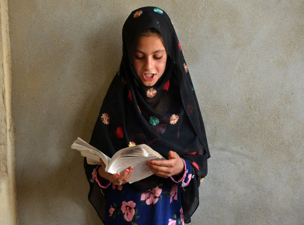 <p>An Afghan girl reads a book inside a one-classroom private educational center in Panjwai district of Kandahar</s>