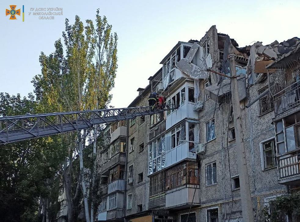 <p>A rescuer helps a man to be evacuated from a residential building hit by a Russian military strike</p>