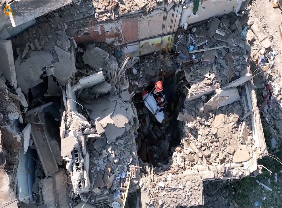 <p>Rescue workers pull out a body from a residential building hit by a Russian military strike</磷>