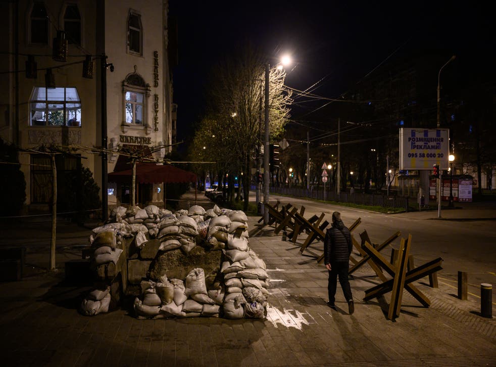 <p>A pedestrian walks along a street past anti-tank obstacles shortly before a curfew in Dnipro </s>