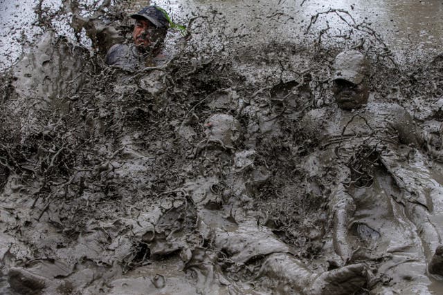 People play in mud water in a paddy field on National Paddy Day in Tokha village, on the outskirt of capital Kathmandu, Nepal