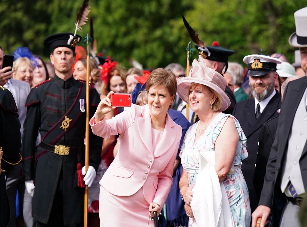First Minister Nicola Sturgeon takes a picture with a guest during the garden party (Jane Barlow/PA)